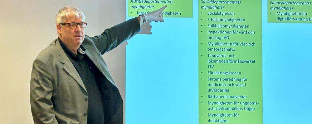 Ulf Petrusson står vid whiteboard och visar grafer