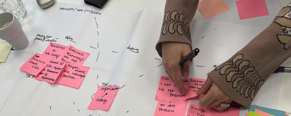 två händer som skriver post-it lappar 